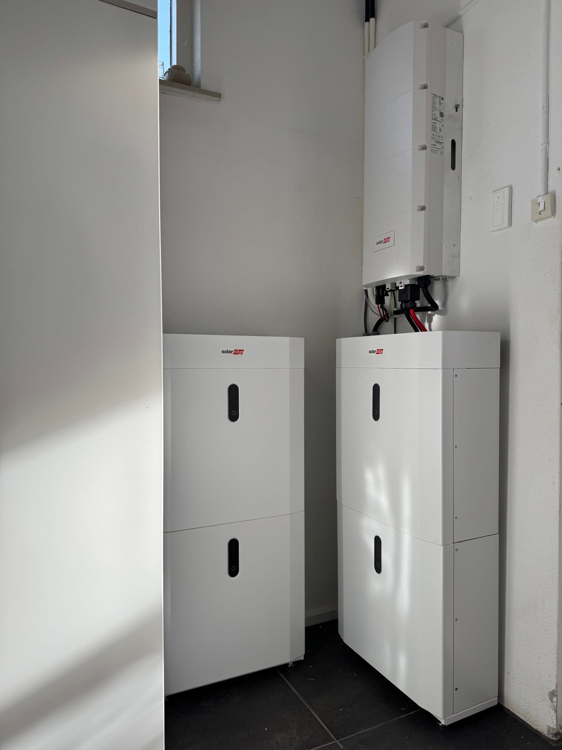 Twee SolarEdge thuisbatterijen met omvormer in een bijkeuken