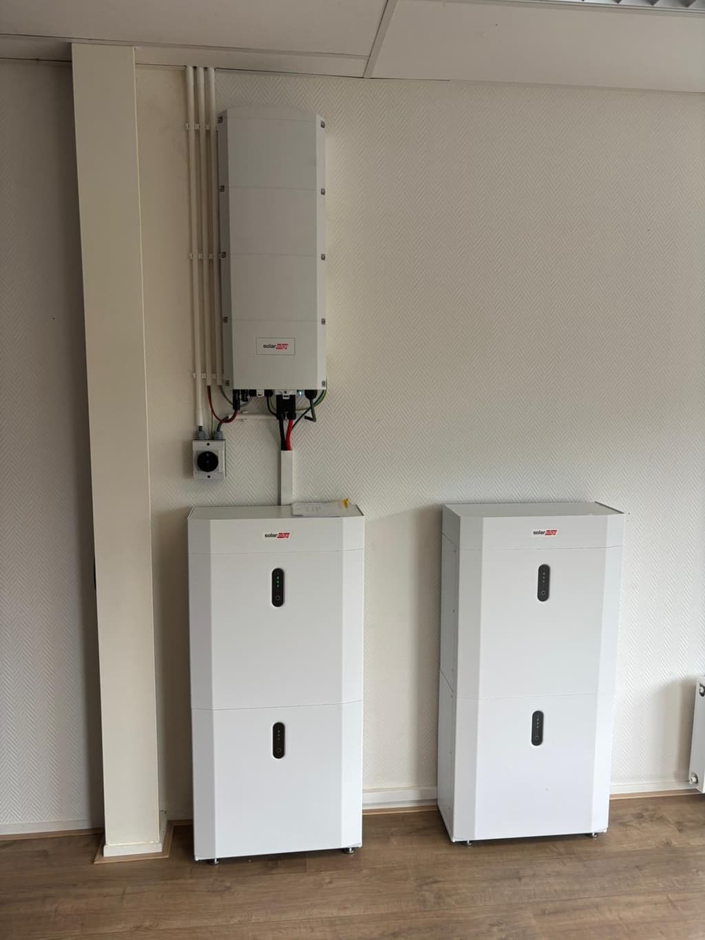 Drie SolarEdge thuisbatterijen met omvormer aan de muur